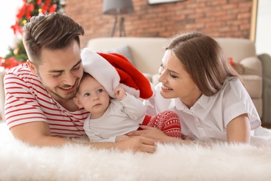 Photo of Happy couple with baby celebrating Christmas together at home