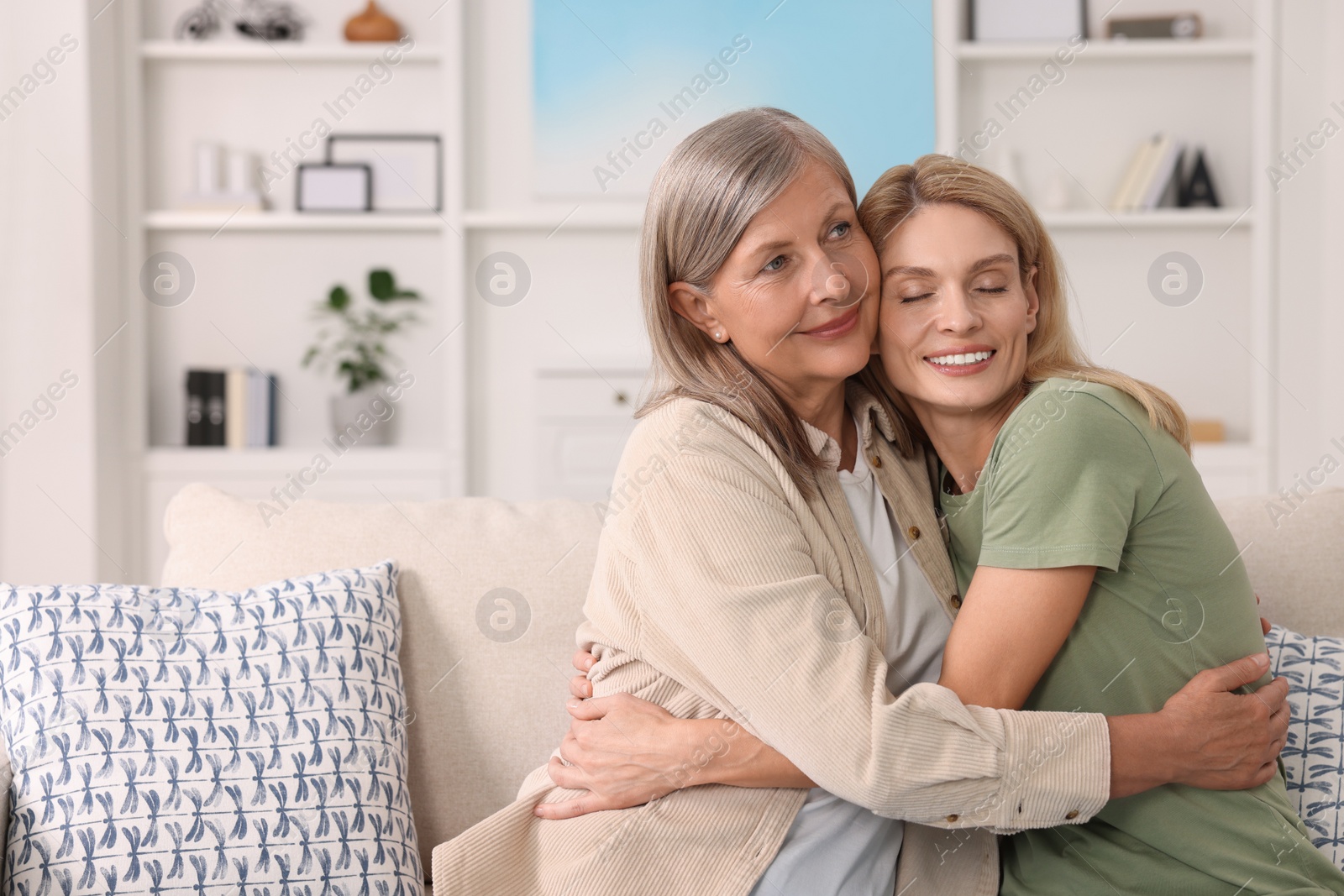 Photo of Happy mature mother and her daughter hugging at home