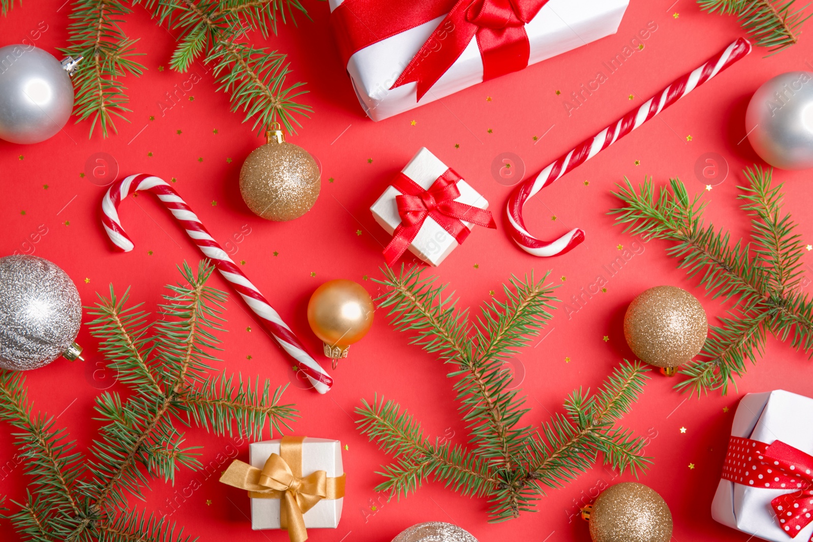 Photo of Flat lay composition with Christmas tree branches, festive decor and gift boxes on color background