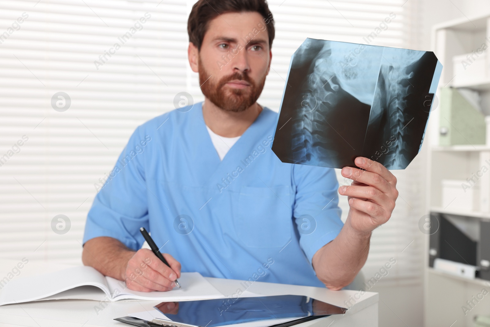 Photo of Doctor examining neck MRI scan in hospital, focus on hand