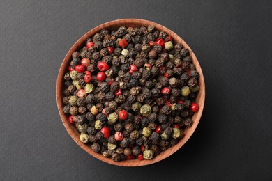 Photo of Bowl with peppercorn mix on grey background, top view