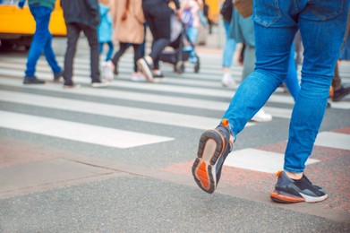 People crossing street in city, closeup view