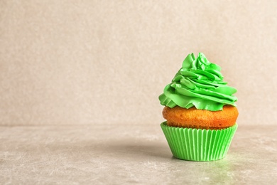 Photo of Delicious birthday cupcake with cream on light background