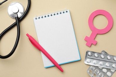 Photo of Flat lay composition with female gender sign and stethoscope on beige background. Women's Health concept