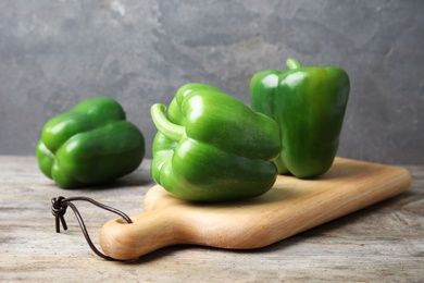 Photo of Board with ripe paprika peppers on wooden table