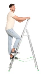 Young handsome man climbing up metal ladder on white background