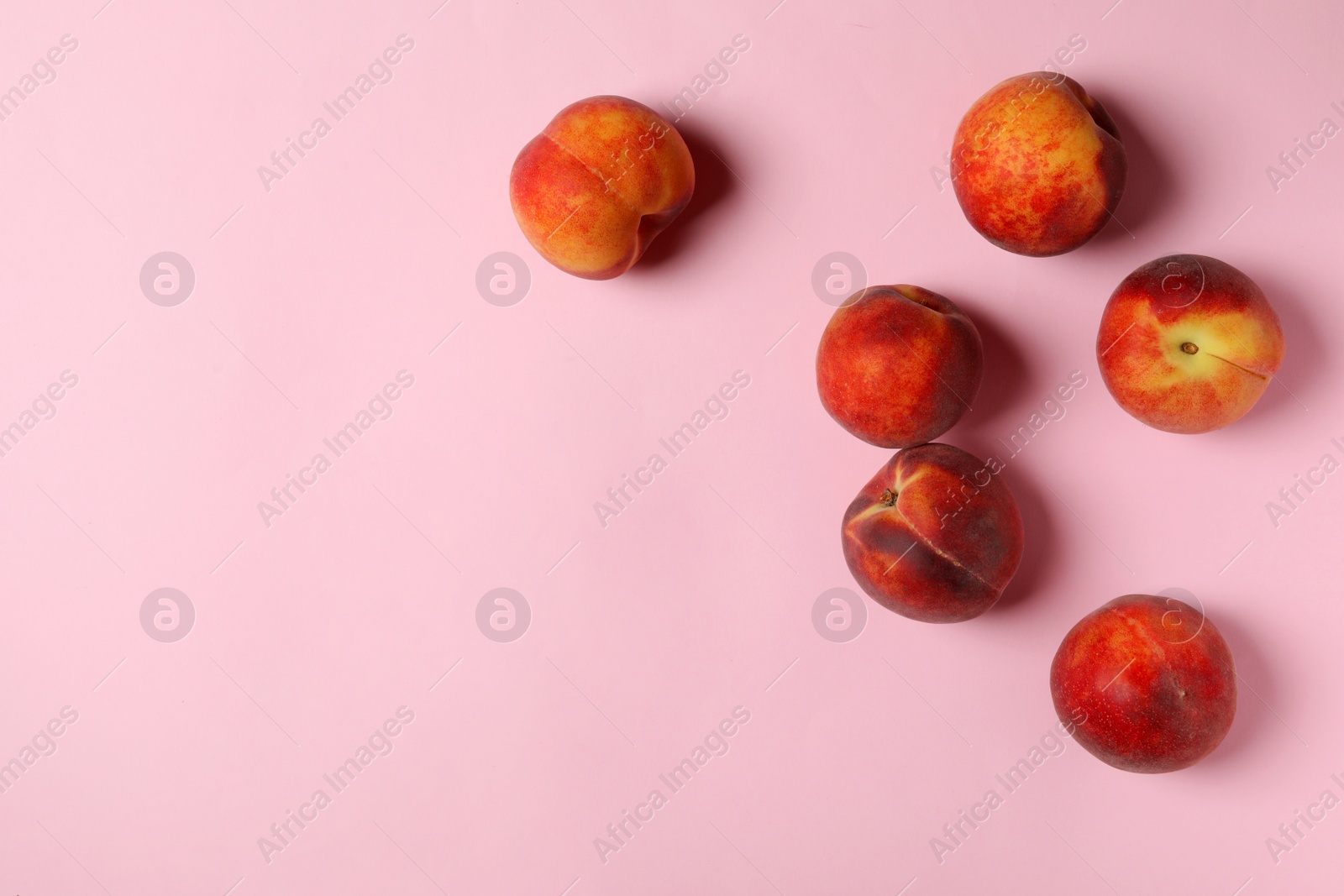 Photo of Sweet juicy peaches on pink background, top view. Space for text