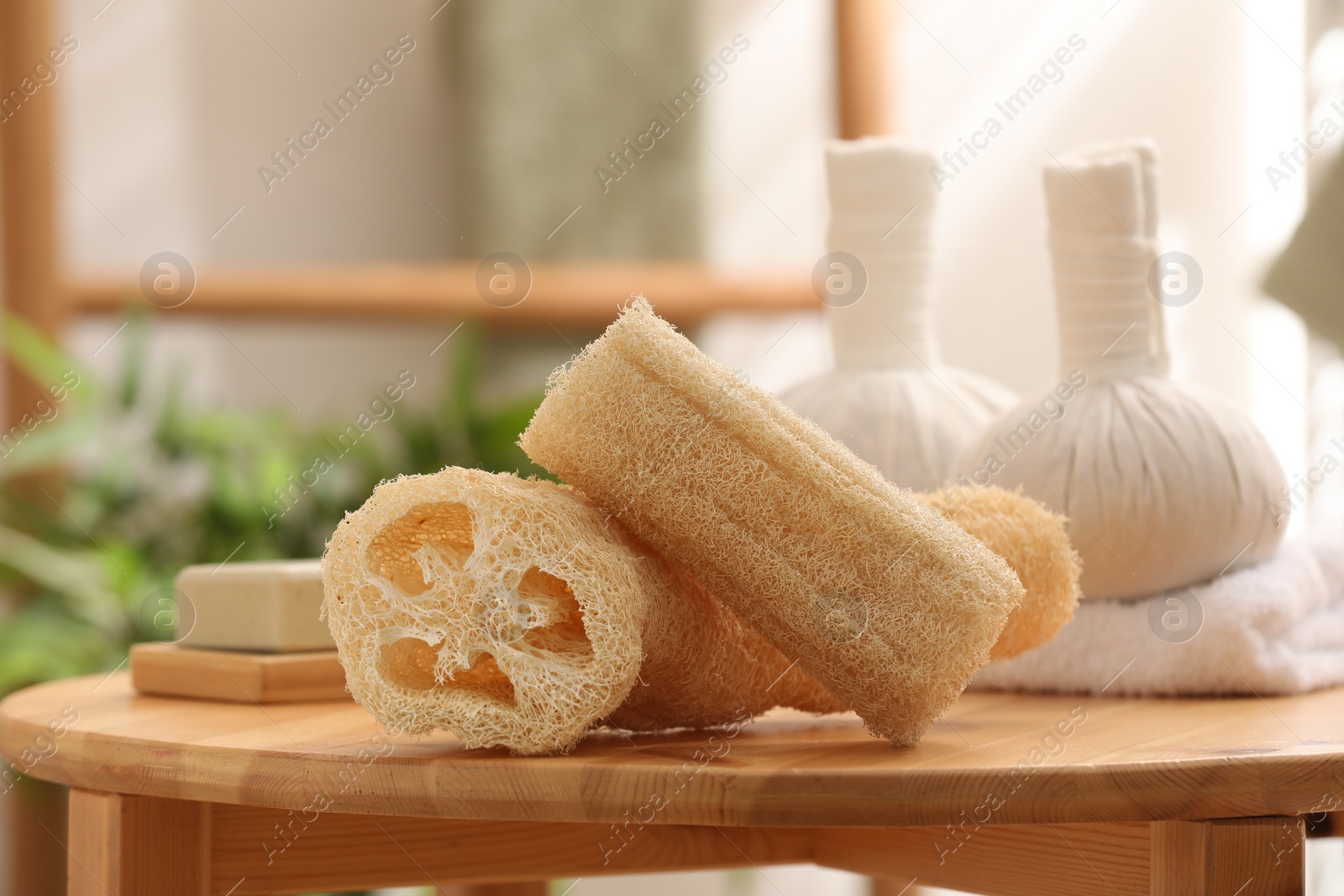 Photo of Loofah sponges on wooden table indoors, closeup. Personal hygiene products