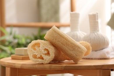 Loofah sponges on wooden table indoors, closeup. Personal hygiene products