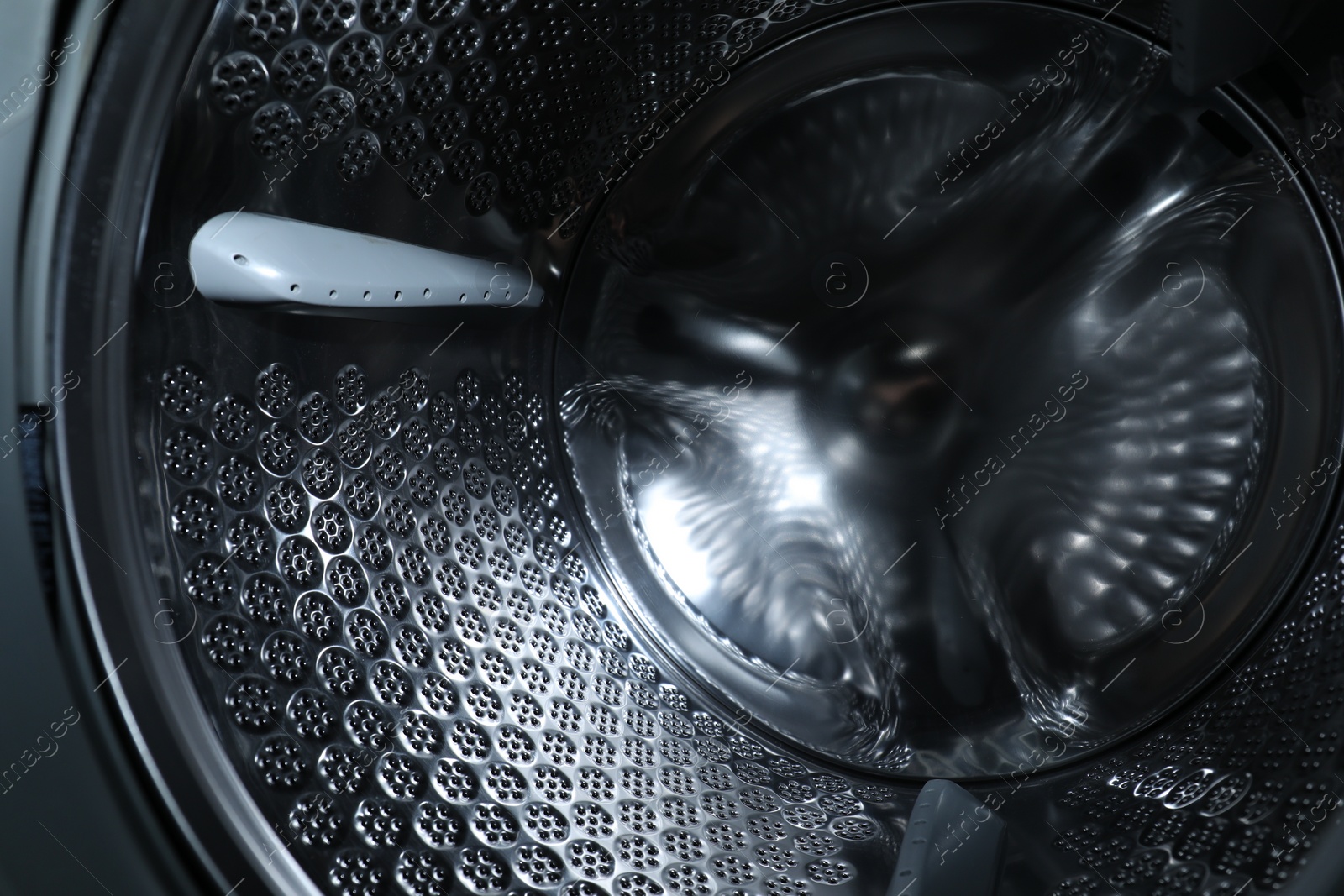 Photo of Empty washing machine drum, closeup. Laundry day