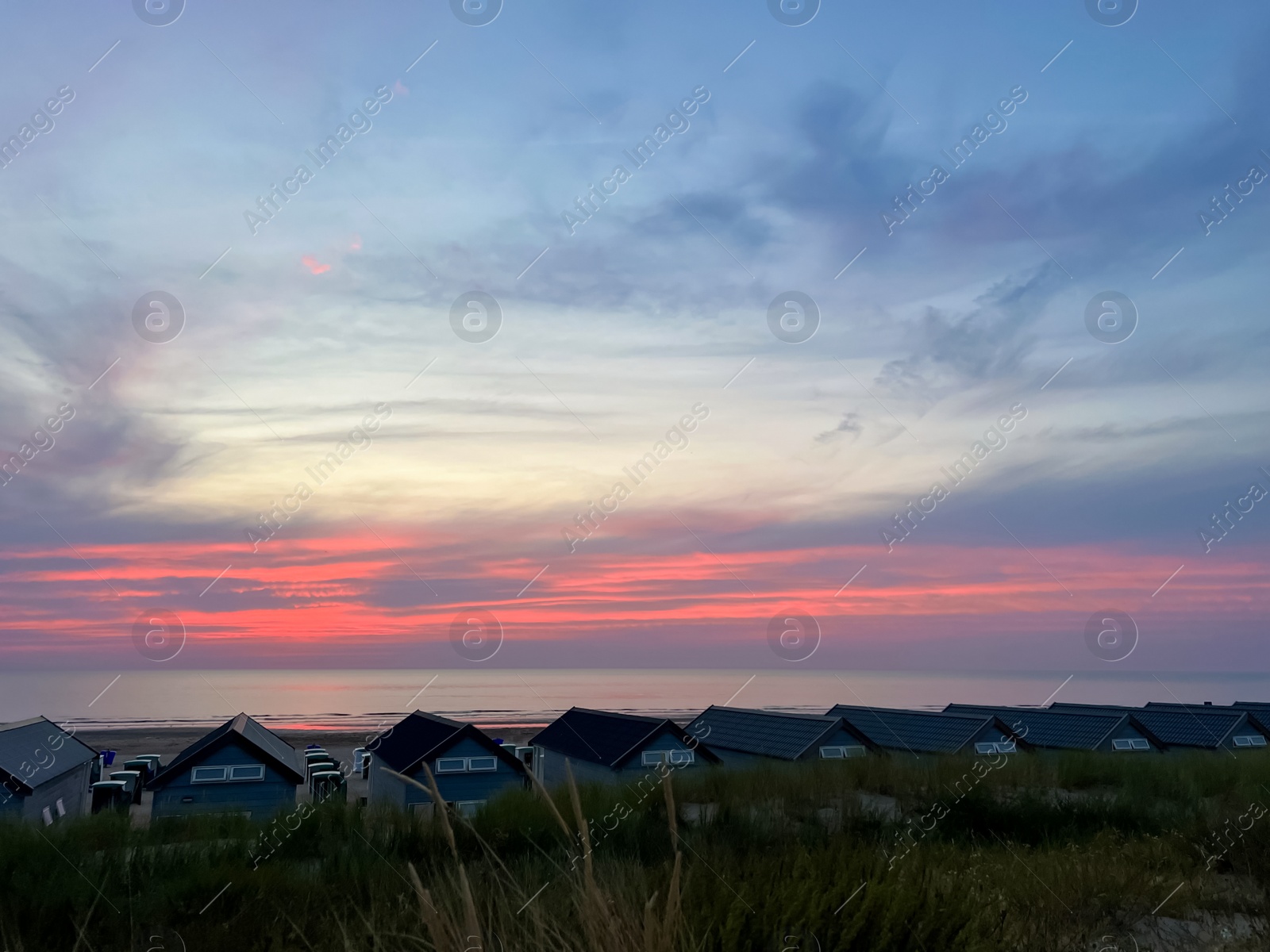 Photo of Many wooden houses on seacoast at sunset