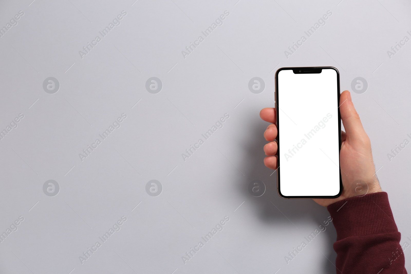 Photo of Man with smartphone on light grey background, top view. Space for text