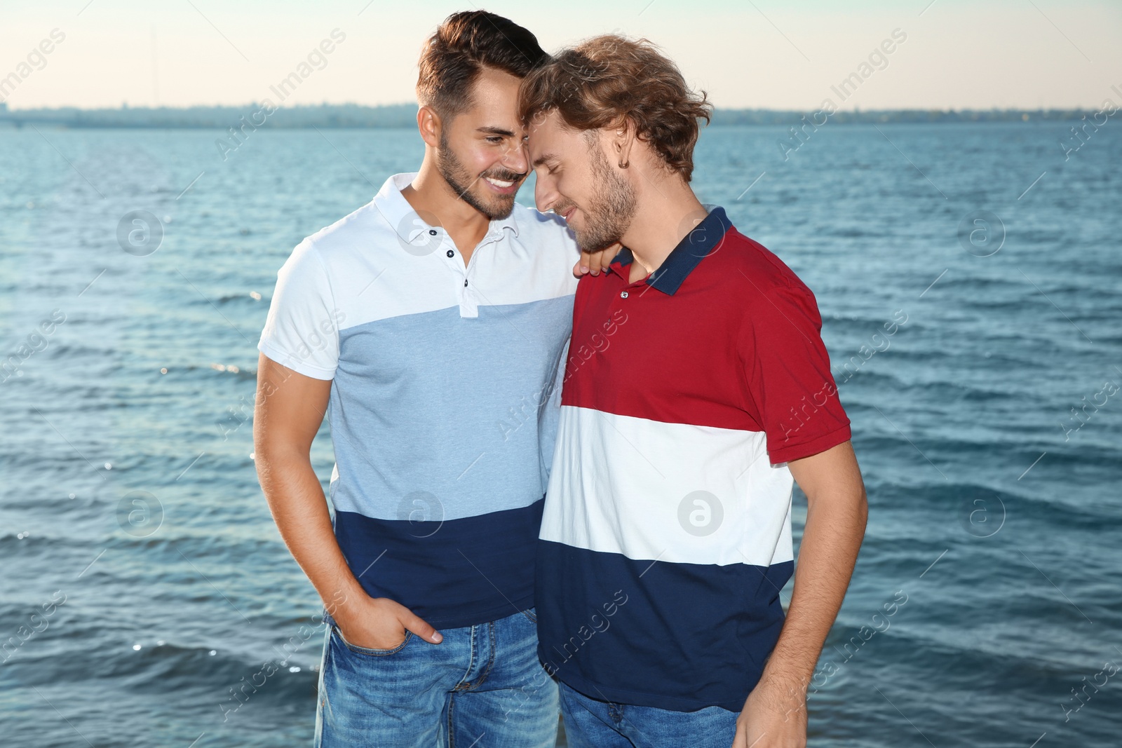 Photo of Happy gay couple standing together at riverside