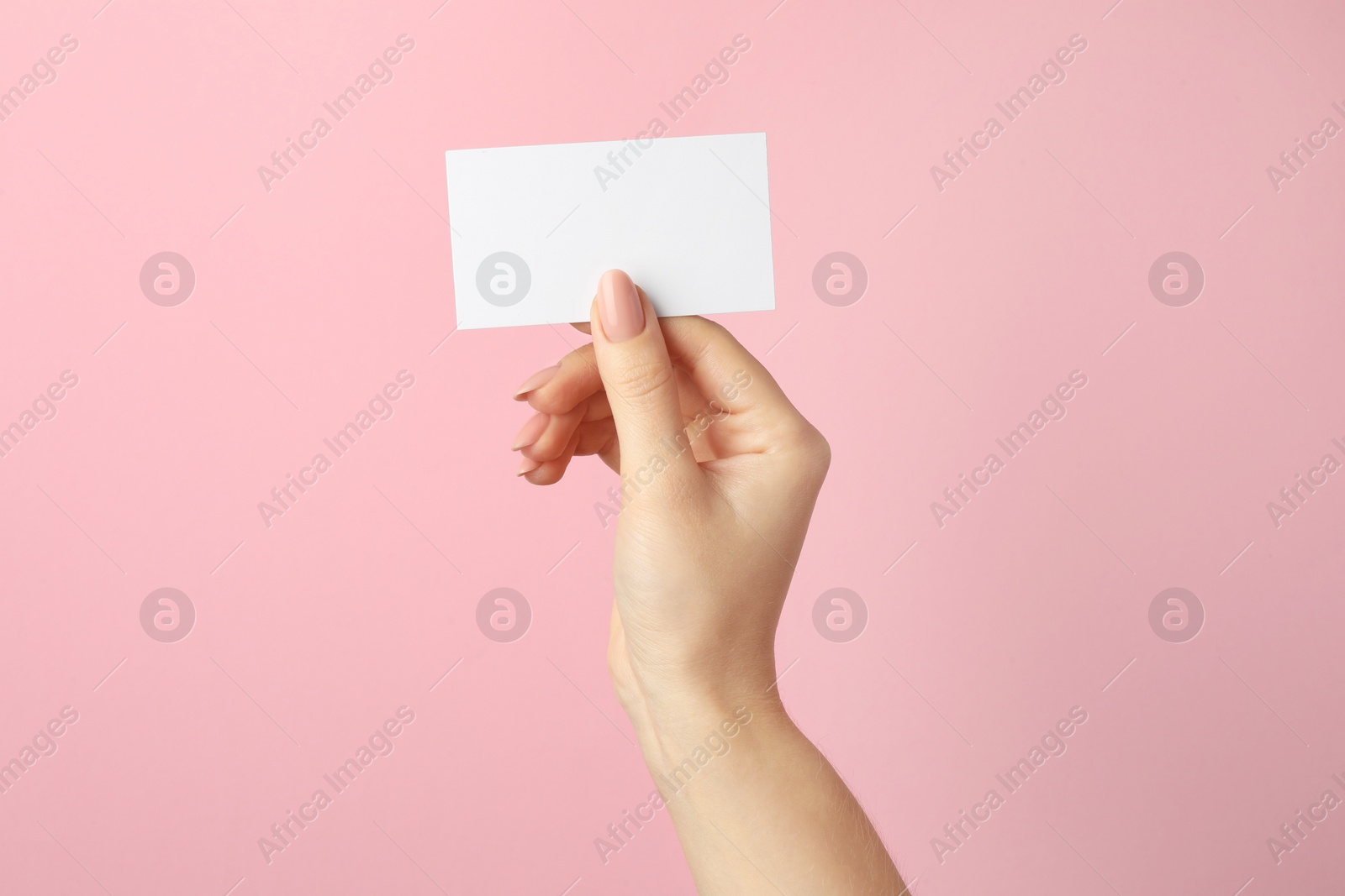 Photo of Woman holding blank business card on pink background, closeup. Mockup for design