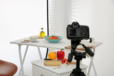 Photo of Professional camera and composition with spaghetti in photo studio. Food photography