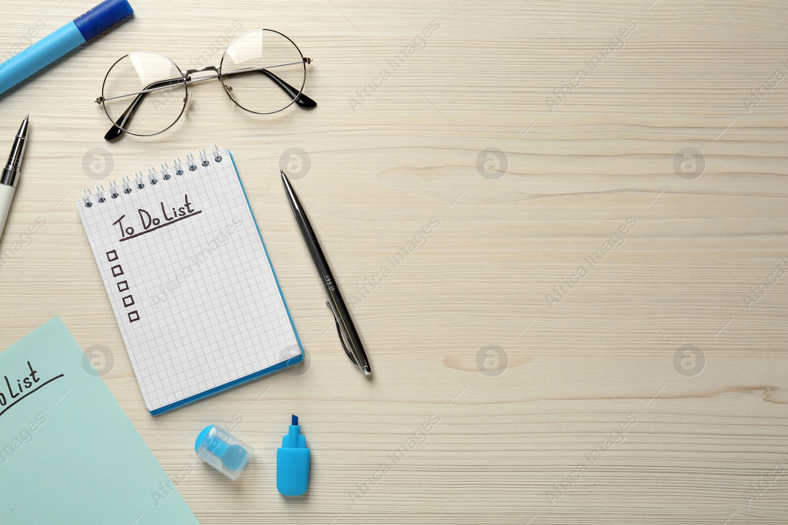 Photo of Flat lay composition with unfilled To Do list in notepad and pens on wooden table, space for text