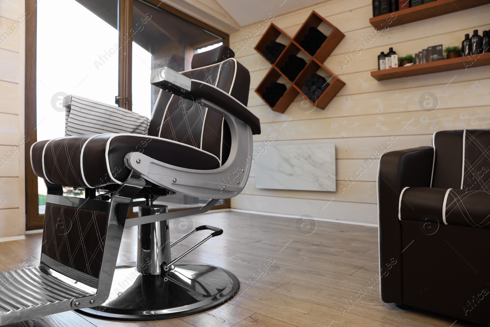 Photo of Stylish barbershop interior with professional armchair and modern wash unit