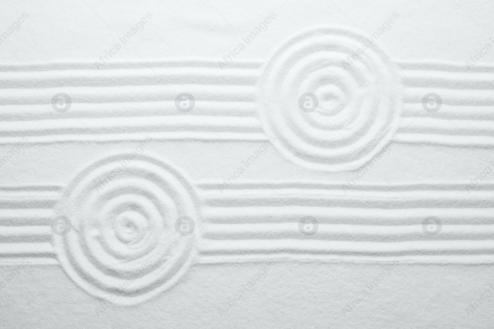 Photo of White sand with pattern as background, top view. Zen, meditation, harmony