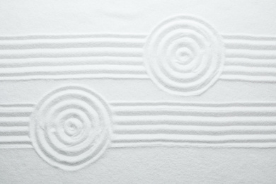 Photo of White sand with pattern as background, top view. Zen, meditation, harmony