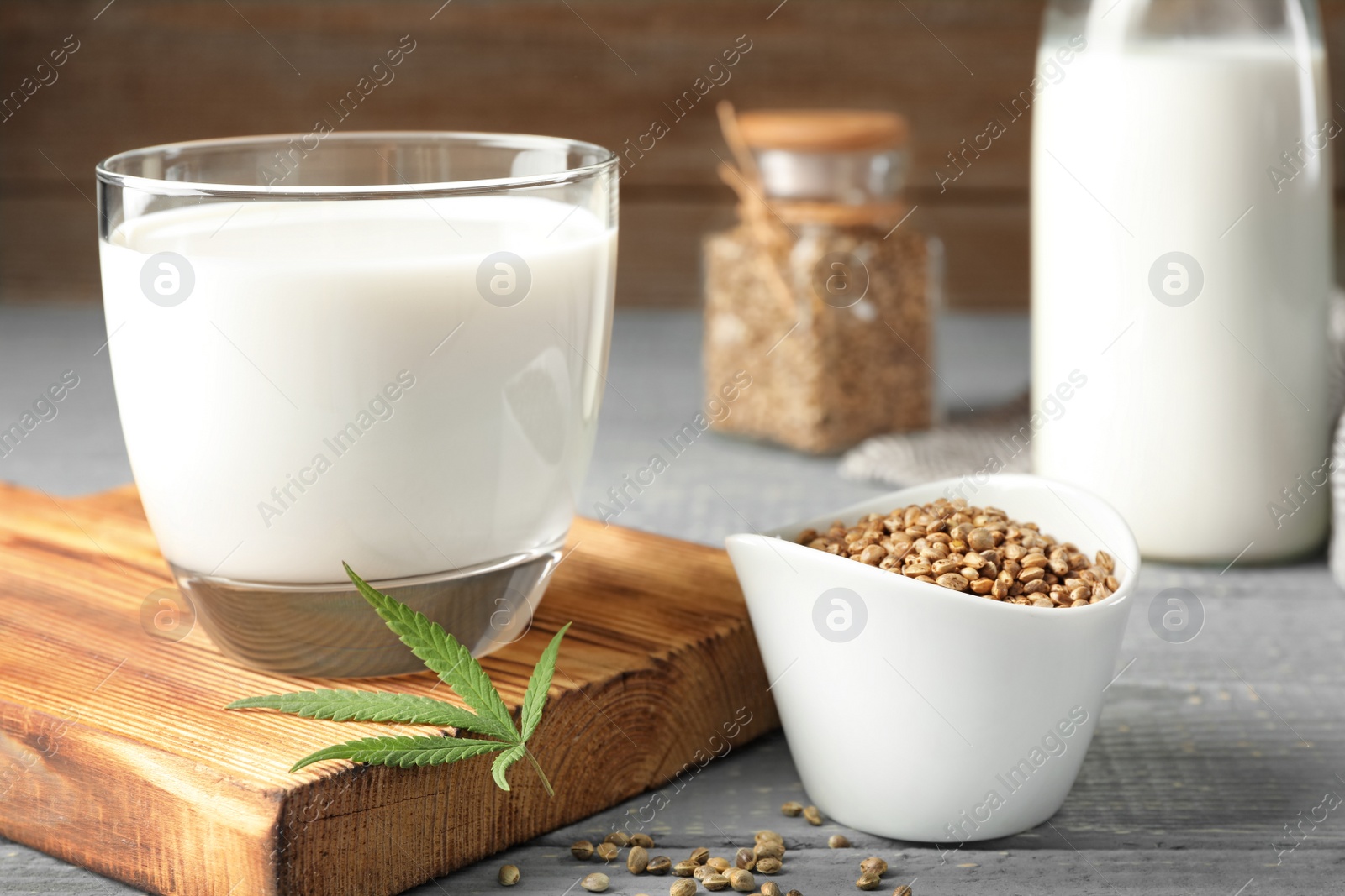 Photo of Composition with glass of hemp milk on grey wooden table, closeup