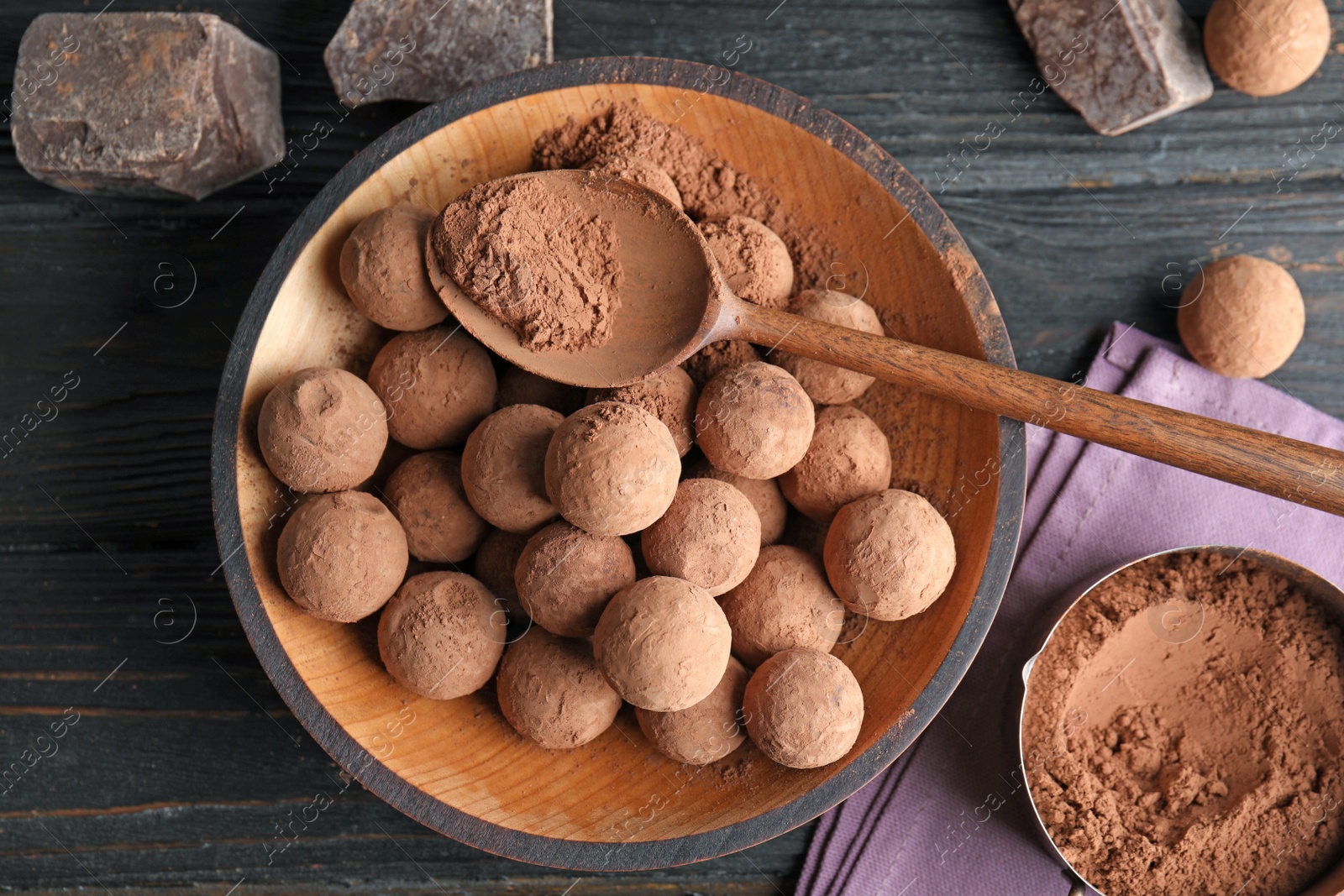 Photo of Plate with chocolate truffles on wooden background, top view