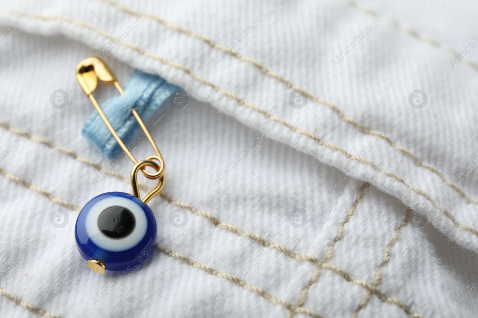 Photo of Evil eye safety pin on clothing, closeup