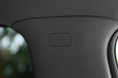 Safety airbag sign on center pillar panel in car, closeup