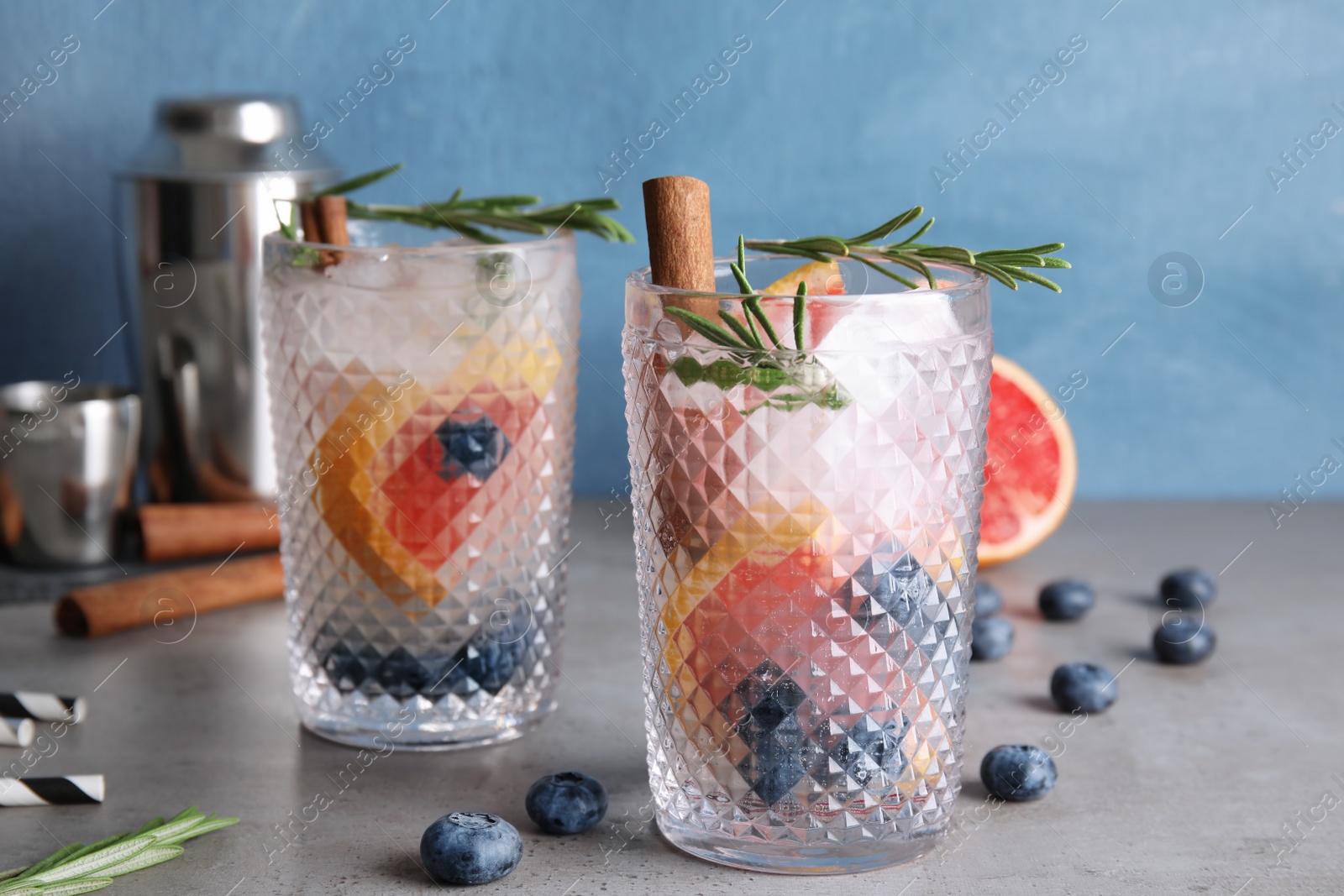 Photo of Tasty refreshing grapefruit cocktail with rosemary on table