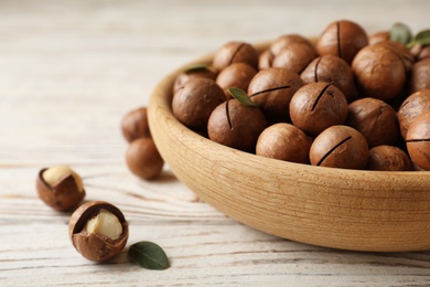 Photo of Plate with organic Macadamia nuts and space for text on wooden background