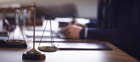Image of Scales of justice and blurred lawyer on background. Banner design