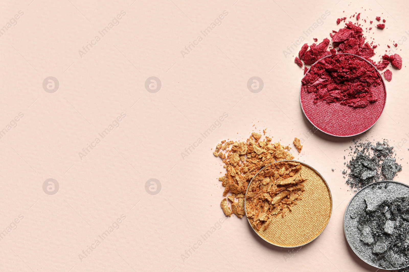 Photo of Different crushed eye shadows on beige background, flat lay. Space for text