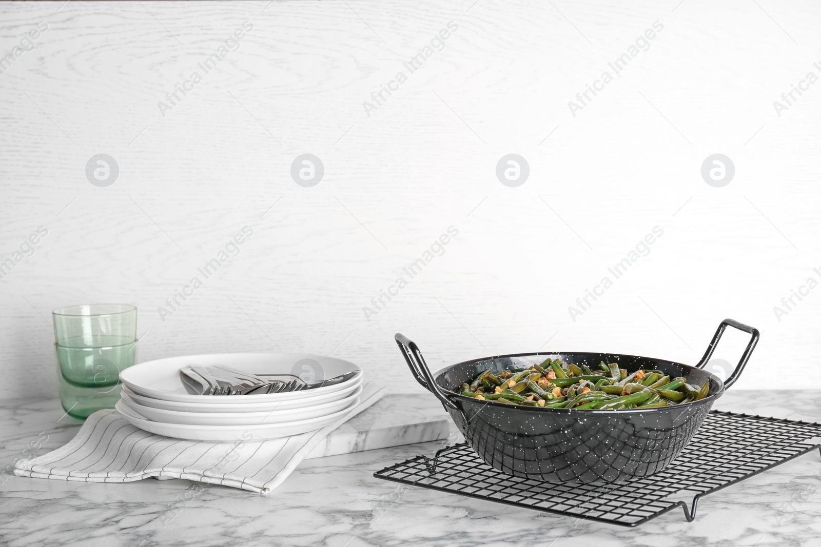 Photo of Yummy green beans with almonds in serving pan on table