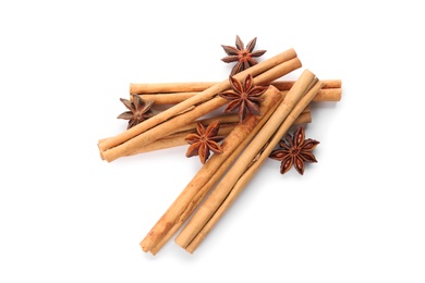 Photo of Aromatic cinnamon sticks and anise isolated on white, top view