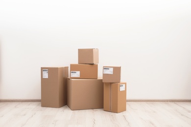 Stacked parcel boxes on floor against light wall