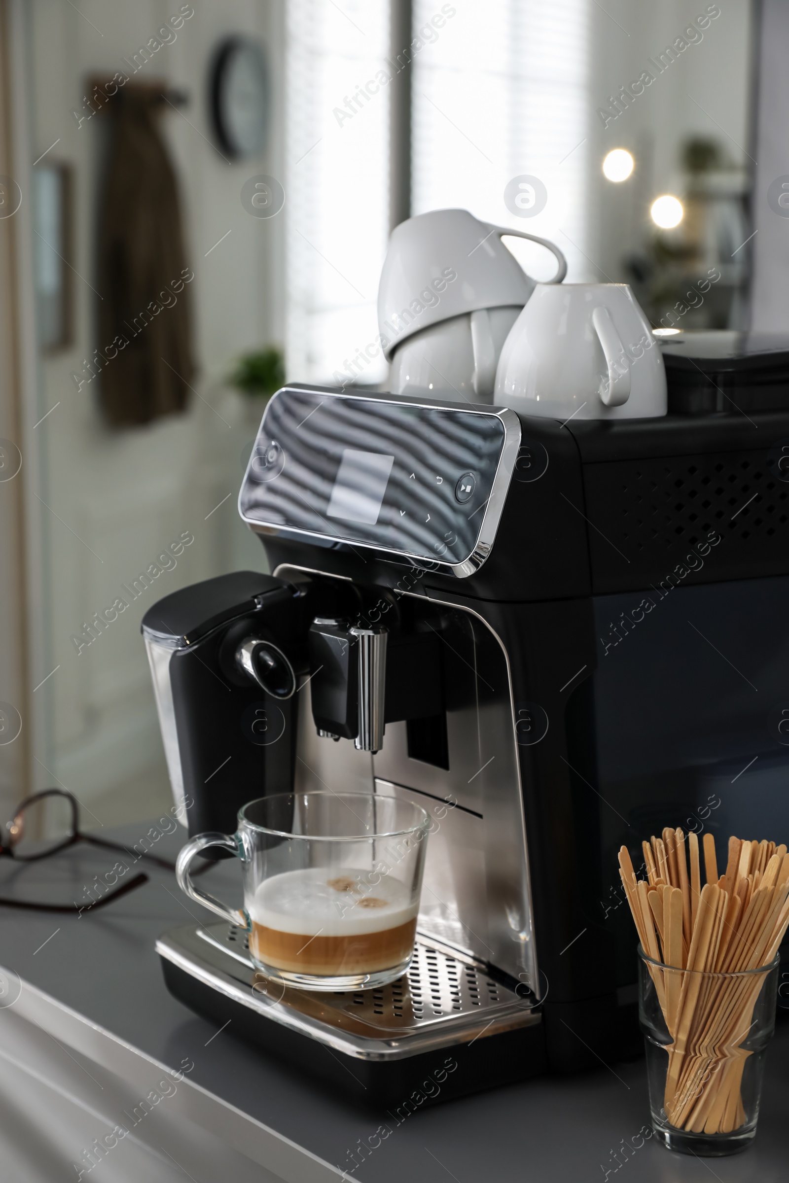 Photo of Modern coffee machine with cup in office