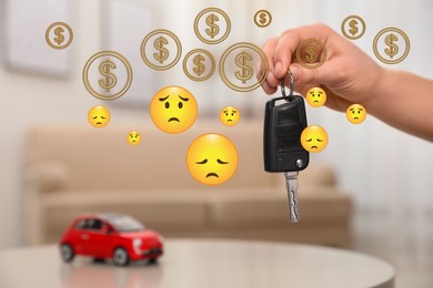 Man with car key indoors, closeup. Sad emoji illustrations and and dollar signs symbolizing buyer's remorse