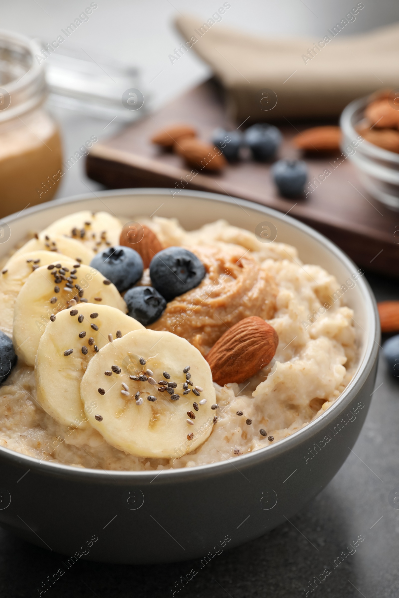 Photo of Tasty oatmeal porridge with toppings served on table, closeup