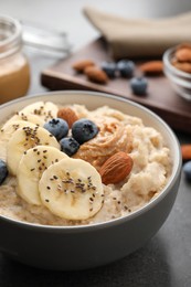 Photo of Tasty oatmeal porridge with toppings served on table, closeup