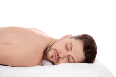 Photo of Handsome man relaxing on massage table against white background. Spa service