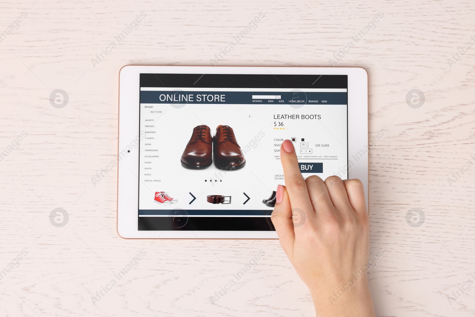 Photo of Woman with tablet shopping online at white wooden table, top view