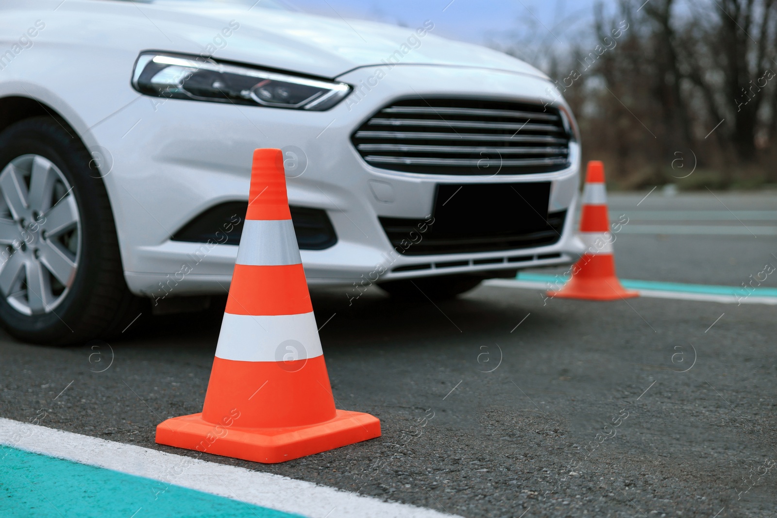 Photo of Modern car at test track, focus on traffic cone. Driving school