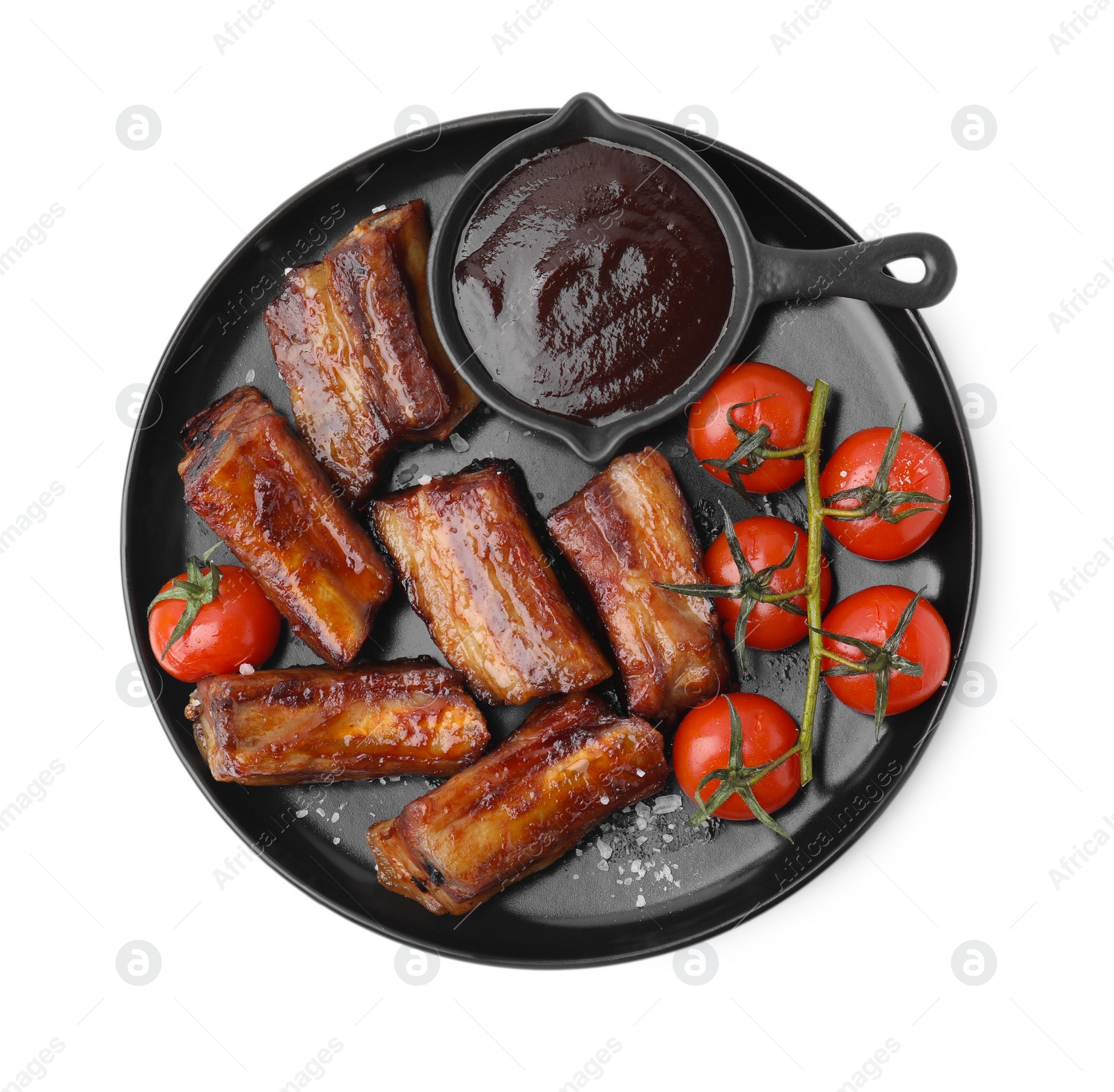 Photo of Tasty roasted pork ribs, sauce and tomatoes isolated on white, top view