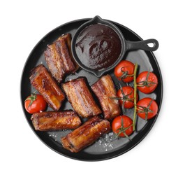 Tasty roasted pork ribs, sauce and tomatoes isolated on white, top view