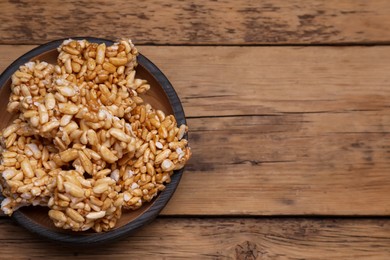 Bowl of puffed rice pieces (kozinaki) on wooden table, top view. Space for text