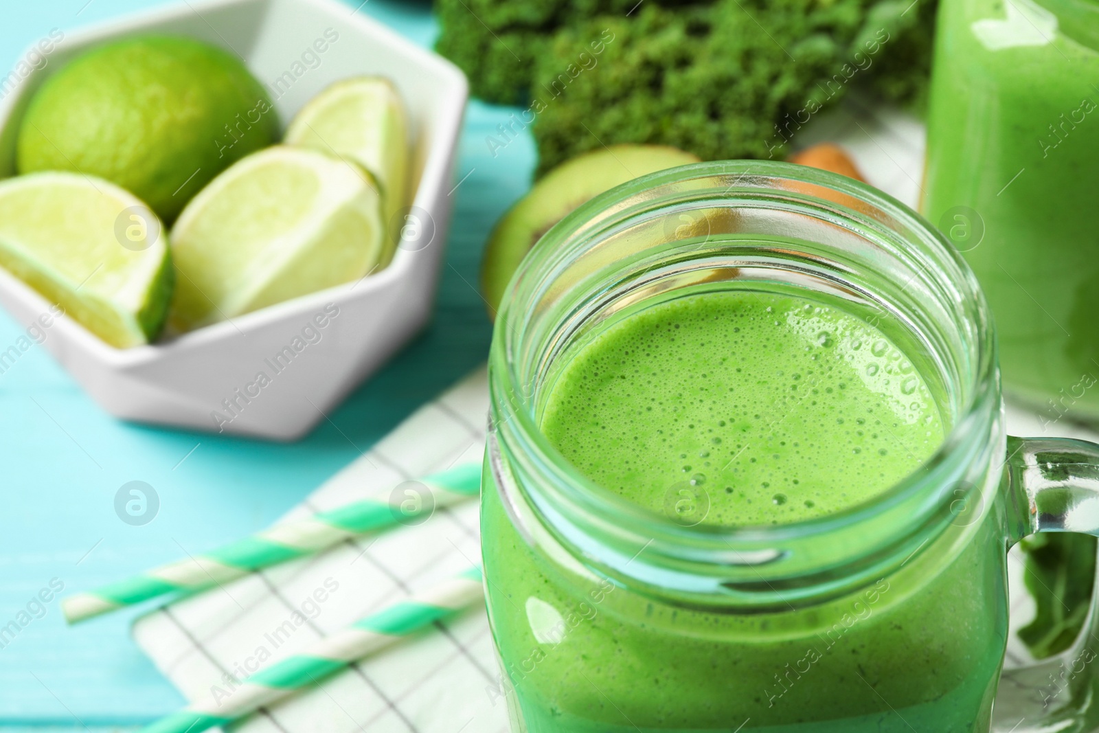 Photo of Tasty fresh kale smoothie on light blue table, closeup