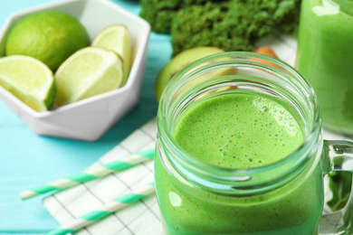 Tasty fresh kale smoothie on light blue table, closeup