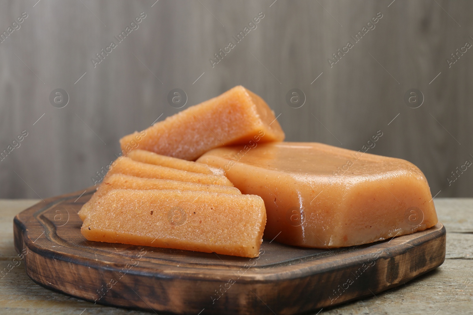 Photo of Tasty sweet quince paste on wooden table, closeup