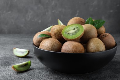 Cut and whole fresh ripe kiwis on grey table