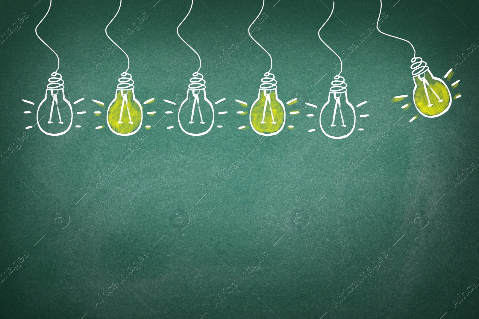 Image of Idea concept. Light bulbs drawn on green chalkboard