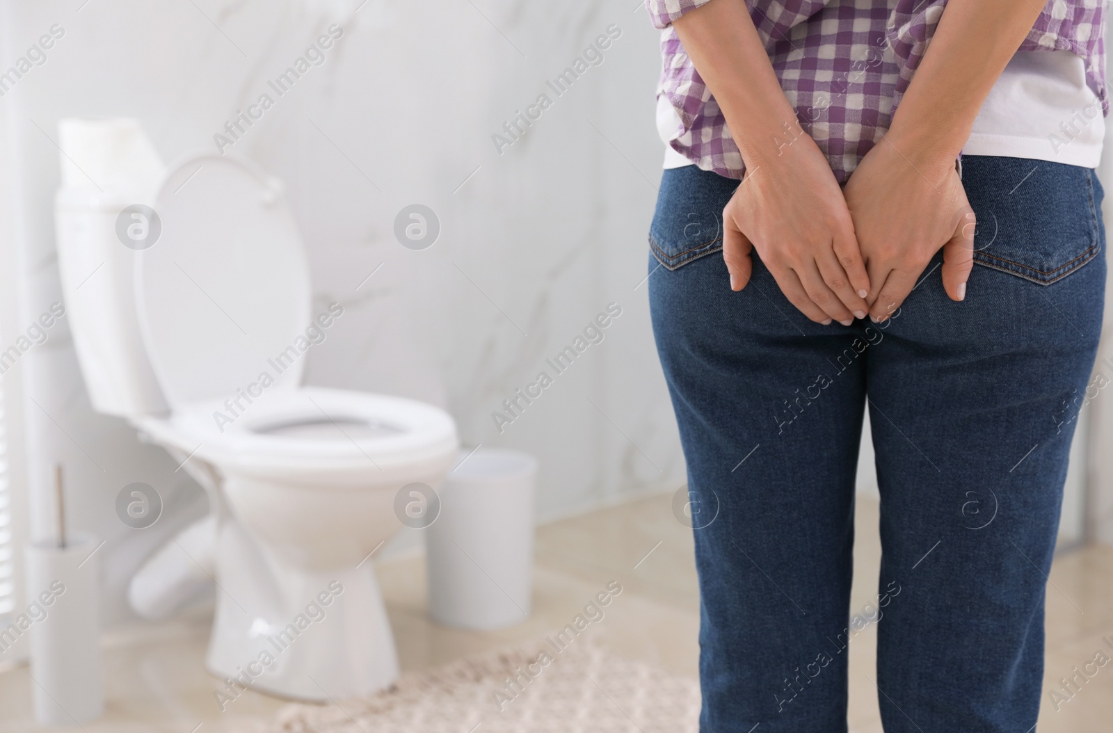 Photo of Woman suffering from hemorrhoid in rest room, closeup